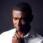 Portrait of a thoughtful man in a crisp white shirt with a serious expression.